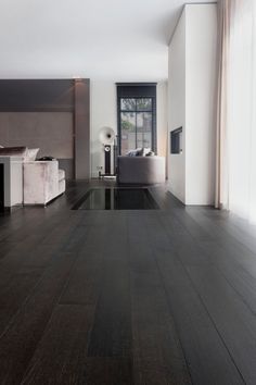 an empty living room with wood floors and white walls, along with large windows on the wall