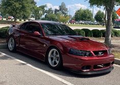 a red sports car is parked on the side of the road next to a stop sign