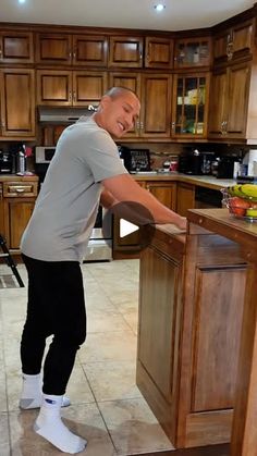 a man standing in front of a kitchen island with his hands on the counter top