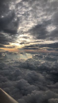 the view from an airplane looking down on clouds and sun rays in the sky above