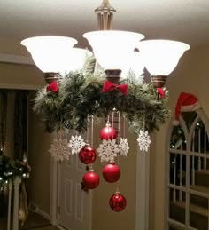 a chandelier with christmas decorations hanging from it