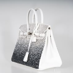 This Hermes custom Swarovski Crystal Birkin 25 dates from 2012, marking the inaugural year of the Birkin 25's storied history. This extraordinary customized piece is meticulously embellished with an array of Swarovski crystals, each reflecting light in a spectacle of brilliance and luxury. The White Epsom leather provides a pristine canvas for the Swarovski crystals, which are carefully arranged to create a mesmerizing effect of shimmering stars against a snowy sky. The bag's structured silhouet Snowy Sky, Most Expensive Handbags, Vintage Kelly, Hand Bags For Women, Hermes Kelly Bag, Reflecting Light, Minimalist Accessories, Expensive Handbags