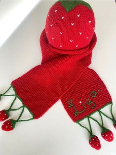 a red knitted scarf with a strawberry on it