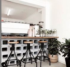 three stools are sitting in front of a bar made out of cinder block blocks