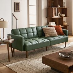 a living room with a green couch and coffee table in front of a bookshelf