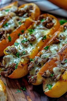 three stuffed peppers on a cutting board with cheese and meat in the middle, ready to be eaten