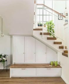 the stairs in this house have plants growing on them, and storage drawers below it