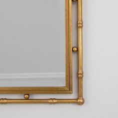 a gold framed mirror hanging on the wall