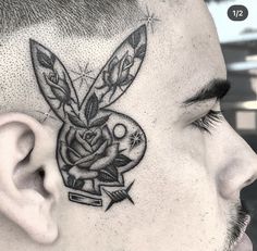 a man with a tattoo on his head has a rabbit in it's ear