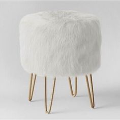 a white stool with gold legs and fur