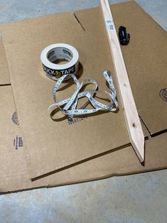 some tape and scissors are laying on top of cardboard