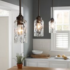 three lights hanging from a ceiling in a kitchen