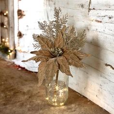 a vase filled with flowers sitting on top of a floor next to a wall covered in lights