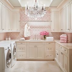 a washer and dryer in a room with chandelier hanging from the ceiling