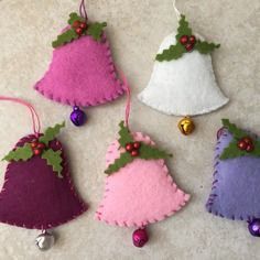 four felt christmas ornaments hanging on a wall