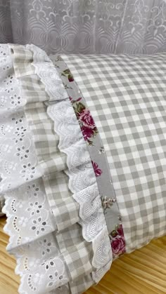 a close up of a pillow on a wooden floor with lace and fabric ruffles