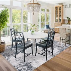 a dining room table with four chairs and a chandelier hanging from the ceiling