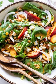 a salad with peaches, onions and nuts in a bowl