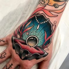 a person's hand with tattoos on it and an image of a fish in the water