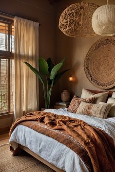 a large bed sitting in a bedroom next to a window with two hanging baskets above it