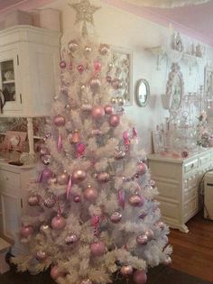 a white christmas tree with pink and silver ornaments