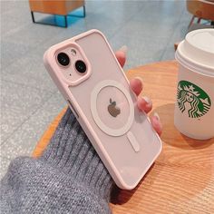 a person holding an iphone case with a coffee cup in the background