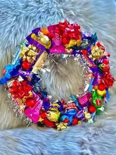 a wreath made out of candies and chocolates on top of a furry surface