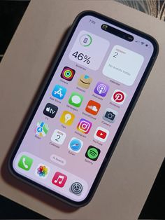 an iphone sitting on top of a table next to a cardboard box filled with icons