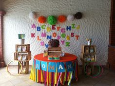 there is a colorful table with letters on it and decorations around the table for children's birthdays