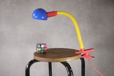 a desk lamp sitting on top of a wooden chair next to a rubik rubik rub