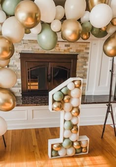 a number one made out of balloons in front of a fireplace