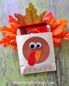 a paper bag with a turkey on it sitting next to some leaves and pencils