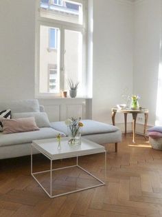 a living room filled with lots of furniture next to a wall mounted clock on the wall