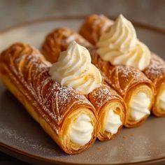 three pastries on a plate topped with whipped cream