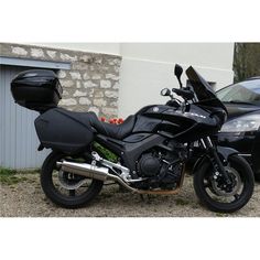 a black motorcycle parked next to a car