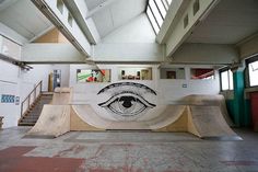 a skateboard park with an eye painted on the wall