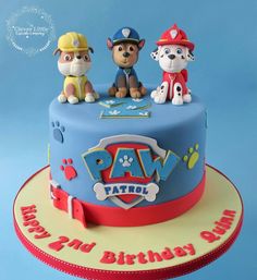 a birthday cake with paw patrol figures on top