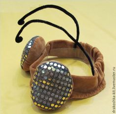 a pair of headbands with sequins and beads on them sitting on a yellow surface