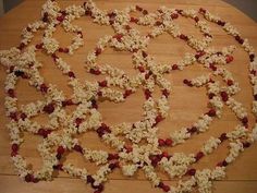 a wooden table topped with lots of white and red flowers covered in small pieces of wood