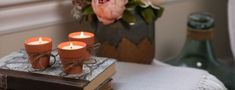 three candles are placed on top of an old book