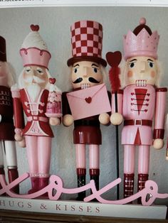 nutcrackers are lined up on the shelf in front of a sign that says love hugs kisses