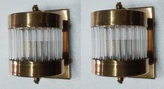 two brass sconces with glass rods on them