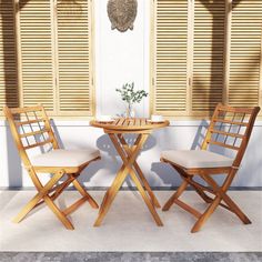 two chairs and a table in front of shuttered windows