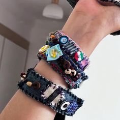 the woman is wearing two bracelets made out of old jeans and fabric pieces with buttons on them