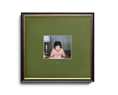 a framed photograph of a woman sitting at a table