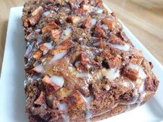 a close up of a piece of cake on a plate with icing and nuts