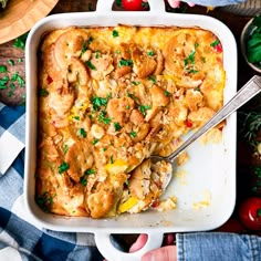 a casserole dish with chicken and vegetables in it on a blue checkered table cloth