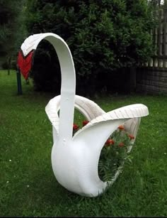 a white swan sculpture sitting on top of a lush green field