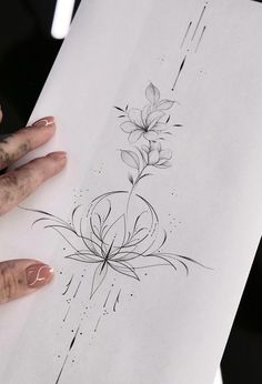 a woman's hand holding up a piece of paper with flowers on it