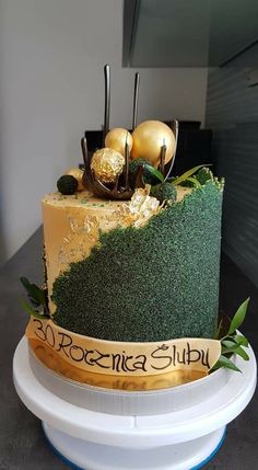 a cake decorated with green grass and gold ornaments